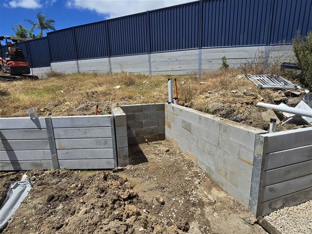 Concrete sleeper and besser block retaining wall corner under construction